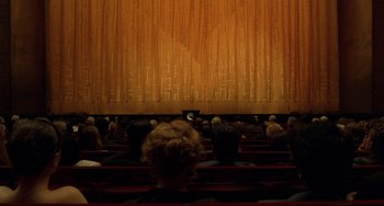 Movie still from “Margaret” (2011), directed by Kenneth Lonergan – People are sitting in a theater watching a movie; Extreme Wide shot, High angle