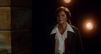 Movie still from “Margaret” (2011), directed by Kenneth Lonergan – A woman wearing a suit and tie standing in a dark room; Medium shot, Over the shoulder angle