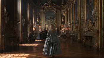 Movie still from “Marie Antoinette” (2006), directed by Sofia Coppola – A woman in a long dress in an ornate room; Wide shot, High angle