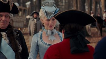 Movie still from “Marie Antoinette” (2006), directed by Sofia Coppola – A woman in a blue dress with a hat on her head; Medium shot, Over the shoulder angle