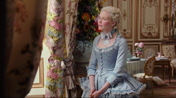 Movie still from “Marie Antoinette” (2006), directed by Sofia Coppola – A woman dressed in period clothing sitting in front of a mirror; Medium shot, Over the shoulder angle