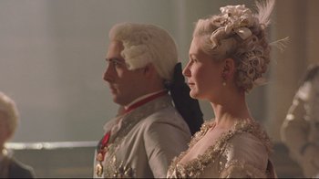 Movie still from “Marie Antoinette” (2006), directed by Sofia Coppola – A man and a woman dressed in period clothing; Medium shot, Low angle