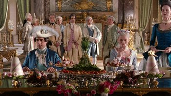 Movie still from “Marie Antoinette” (2006), directed by Sofia Coppola – A group of people standing around a dinner table; Medium shot, Low angle