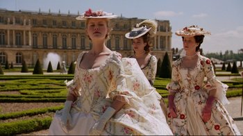 Movie still from “Marie Antoinette” (2006), directed by Sofia Coppola – A group of women dressed in period clothing walk through a park; Medium shot, Low angle