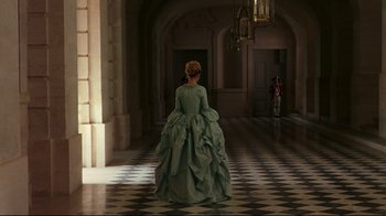 Movie still from “Marie Antoinette” (2006), directed by Sofia Coppola – A woman in a green dress standing in a room; Wide shot, High angle