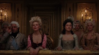 Movie still from “Marie Antoinette” (2006), directed by Sofia Coppola – A group of people sitting at a table wearing period costumes; Medium shot, Low angle