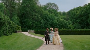 Movie still from “Marie Antoinette” (2006), directed by Sofia Coppola – A group of people walking down a path in a park; Extreme Wide shot, High angle