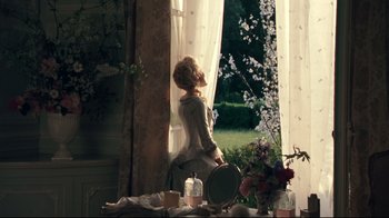 Movie still from “Marie Antoinette” (2006), directed by Sofia Coppola – A woman standing in front of a window looking outside; Wide shot, Low angle