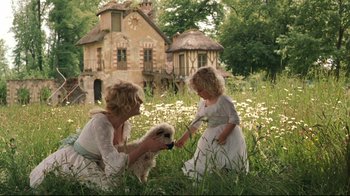 Movie still from “Marie Antoinette” (2006), directed by Sofia Coppola – A woman and a child in a field with a dog; Wide shot, Low angle