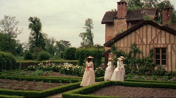 Movie still from “Marie Antoinette” (2006), directed by Sofia Coppola – A group of women dressed in period clothing walking through a garden; Extreme Wide shot, High angle