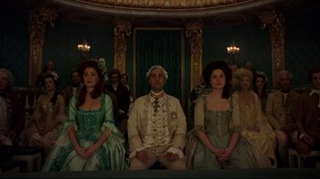 Movie still from “Marie Antoinette” (2006), directed by Sofia Coppola – A group of people sitting next to each other in a room; Wide shot, Low angle