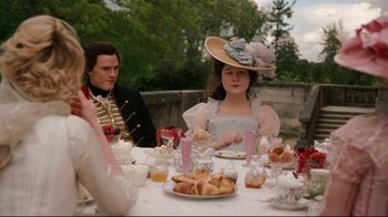 Movie still from “Marie Antoinette” (2006), directed by Sofia Coppola – A man and a woman sitting at a table with food; Medium shot, Over the shoulder angle