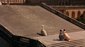 Movie still from “Marie Antoinette” (2006), directed by Sofia Coppola – A group of people sitting on the steps of a building; Extreme Wide shot, High angle
