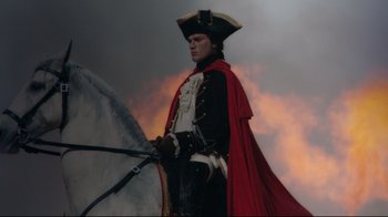 Movie still from “Marie Antoinette” (2006), directed by Sofia Coppola – A man dressed as a pirate holding two swords; Medium shot, Low angle