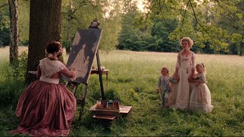 Movie still from “Marie Antoinette” (2006), directed by Sofia Coppola – Two women and a child are standing in the grass; Wide shot, Over the shoulder angle