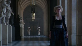 Movie still from “Marie Antoinette” (2006), directed by Sofia Coppola – A woman in a black dress standing in a hallway; Wide shot, Low angle