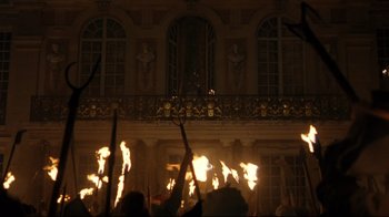 Movie still from “Marie Antoinette” (2006), directed by Sofia Coppola – A group of people holding torches in front of a building; Extreme Wide shot, Low angle