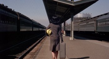 Movie still from “Marnie” (1964), directed by Alfred Hitchcock – A woman walking down a train platform with a suitcase; Wide shot, Low angle