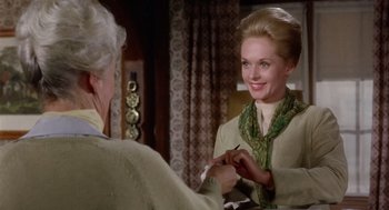 Movie still from “Marnie” (1964), directed by Alfred Hitchcock – An older woman putting a green scarf around a younger woman; Medium shot, Over the shoulder angle