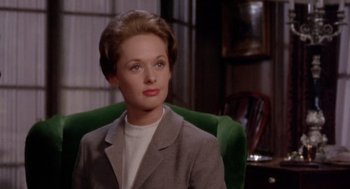 Movie still from “Marnie” (1964), directed by Alfred Hitchcock – A woman sitting in a green chair wearing a gray jacket; Close Up shot, High angle