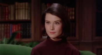 Movie still from “Marnie” (1964), directed by Alfred Hitchcock – A young woman in a maroon sweater in front of bookcases; Close Up shot, High angle