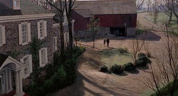 Movie still from “Marnie” (1964), directed by Alfred Hitchcock – Two people walking on a dirt path near a barn; Extreme Wide shot, High angle