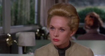 Movie still from “Marnie” (1964), directed by Alfred Hitchcock – An older woman with blonde hair wearing a tan jacket; Close Up shot, Over the shoulder angle