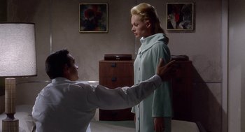 Movie still from “Marnie” (1964), directed by Alfred Hitchcock – A man and a woman are standing in a room; Medium shot, Low angle
