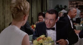 Movie still from “Marnie” (1964), directed by Alfred Hitchcock – A man in a tuxedo sitting in front of a woman in a black dress; Close Up shot, Over the shoulder angle