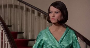 Movie still from “Marnie” (1964), directed by Alfred Hitchcock – A woman in a green dress standing in front of a staircase; Close Up shot, Over the shoulder angle
