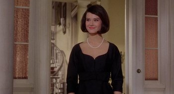 Movie still from “Marnie” (1964), directed by Alfred Hitchcock – A woman wearing a black dress and a pearl necklace; Medium shot, Over the shoulder angle