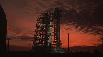 Movie still from “Marooned” (1969), directed by John Sturges – A red and white sky and some clouds and a large tower; Extreme Wide shot, Low angle