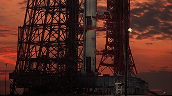 Movie still from “Marooned” (1969), directed by John Sturges – The sun is setting behind a large structure; Extreme Wide shot, Low angle