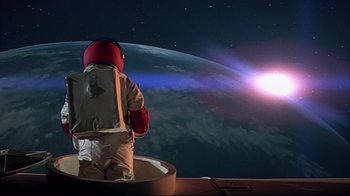 Movie still from “Marooned” (1969), directed by John Sturges – An image of a person in a space suit looking at the earth; Wide shot, Overhead angle