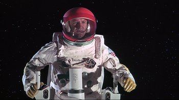 Movie still from “Marooned” (1969), directed by John Sturges – A man in a spacesuit and a red helmet; Medium shot, Low angle