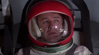 Movie still from “Marooned” (1969), directed by John Sturges – A man wearing a helmet with a headset on his head; Close Up shot, Low angle