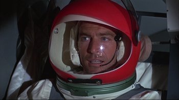 Movie still from “Marooned” (1969), directed by John Sturges – A person wearing a space helmet; Close Up shot, Overhead angle