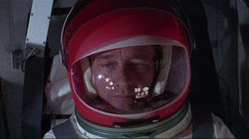 Movie still from “Marooned” (1969), directed by John Sturges – A person wearing a space helmet; Close Up shot, Overhead angle