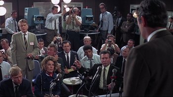 Movie still from “Marooned” (1969), directed by John Sturges – A group of people in a room with microphones; Medium shot, Over the shoulder angle