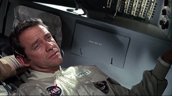 Movie still from “Marooned” (1969), directed by John Sturges – A man in a space suit sitting in front of a computer screen; Close Up shot, Overhead angle