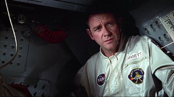 Movie still from “Marooned” (1969), directed by John Sturges – A man wearing a nasa jacket standing in a room; Medium shot, Low angle