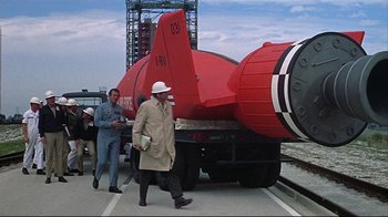 Movie still from “Marooned” (1969), directed by John Sturges – Two men walking next to a large red airplane; Wide shot, High angle