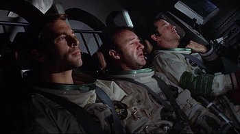 Movie still from “Marooned” (1969), directed by John Sturges – A group of men in space suits sitting in the cockpit of an aircraft; Medium shot, Low angle