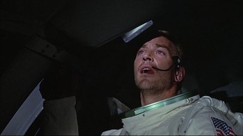 Movie still from “Marooned” (1969), directed by John Sturges – A man in a spacesuit looking up into the sky; Close Up shot, Low angle