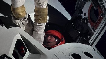 Movie still from “Marooned” (1969), directed by John Sturges – A man in a space suit looking up at the ground; Medium shot, Overhead angle