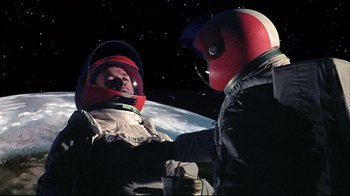 Movie still from “Marooned” (1969), directed by John Sturges – Two people in spacesuits in front of the earth; Medium shot, Overhead angle