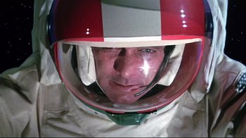 Movie still from “Marooned” (1969), directed by John Sturges – A man wearing a racing suit and a helmet; Close Up shot, Overhead angle