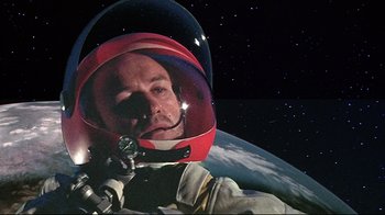 Movie still from “Marooned” (1969), directed by John Sturges – A man in a space suit and a helmet; Close Up shot, Overhead angle