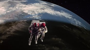 Movie still from “Marooned” (1969), directed by John Sturges – Two astronauts in spacesuits flying in front of the earth; Wide shot, Overhead angle