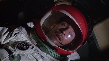 Movie still from “Marooned” (1969), directed by John Sturges – A person wearing a space helmet; Close Up shot, Overhead angle